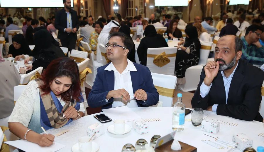 Colleagues work together at a round table during a corporate workshop in a hotel ballroom