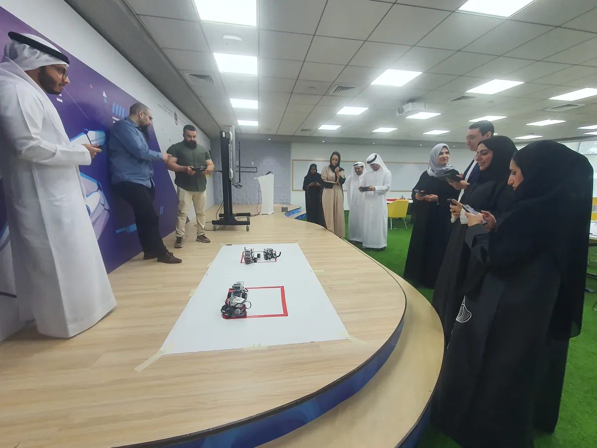 Ministry staff gather around a robot challenge mat during a team building workshop