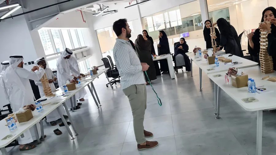 Ajman Municipality staff test tower prototypes on workshop tables during a design thinking workshop